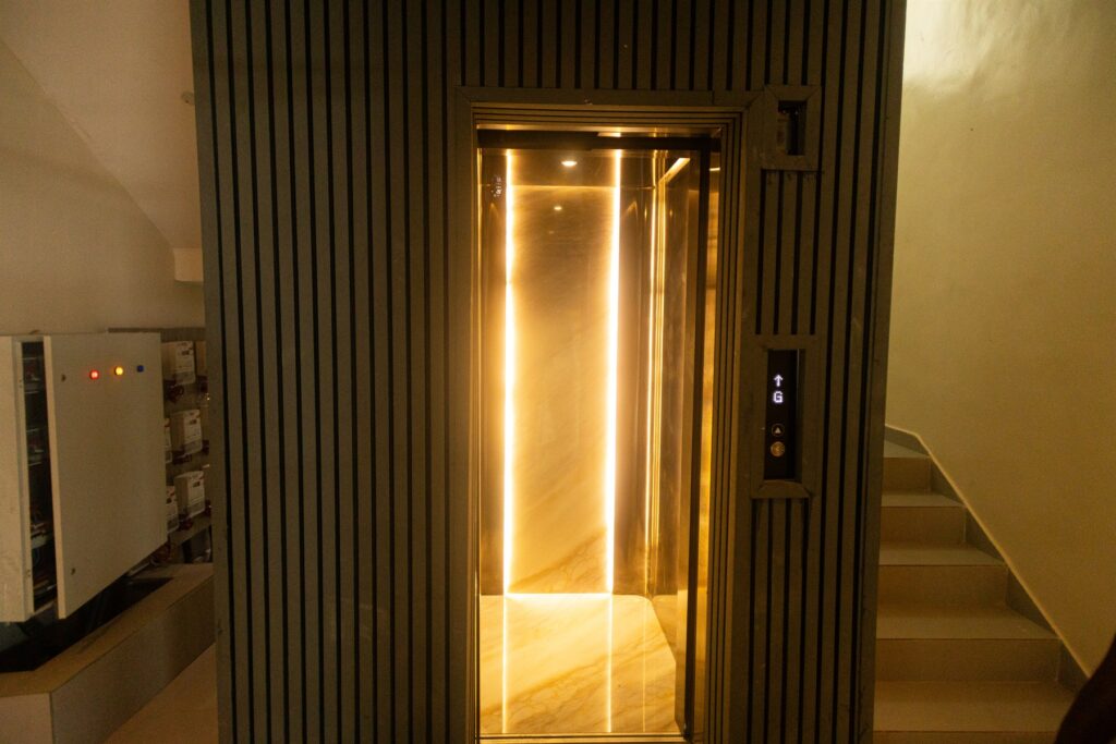 Brum Height 7: Illuminated elevator entrance beside the stairwell